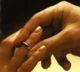 Hand von Frau und Mann beim Anstecken des Ringes